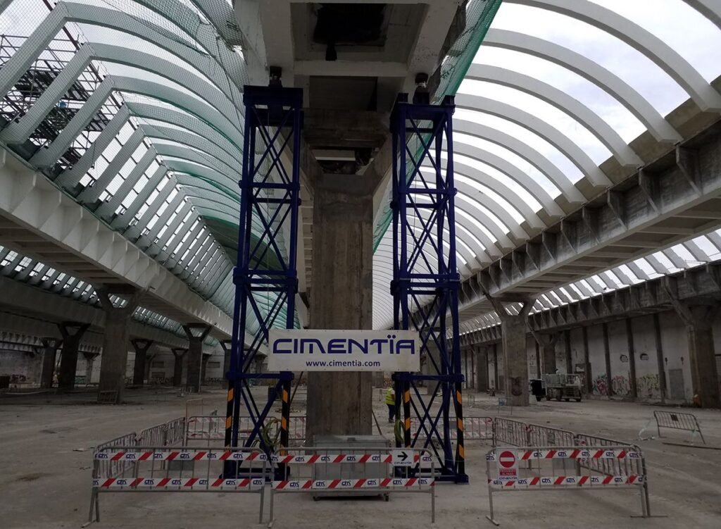 Torres de apeo bajo la estructura de la nave con la pancarta de Cimentia