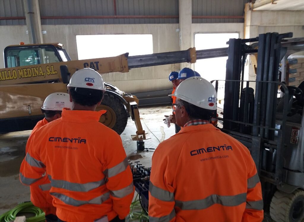 Equipo de Cimentia con uniforme naranja y casco blanco en la obra